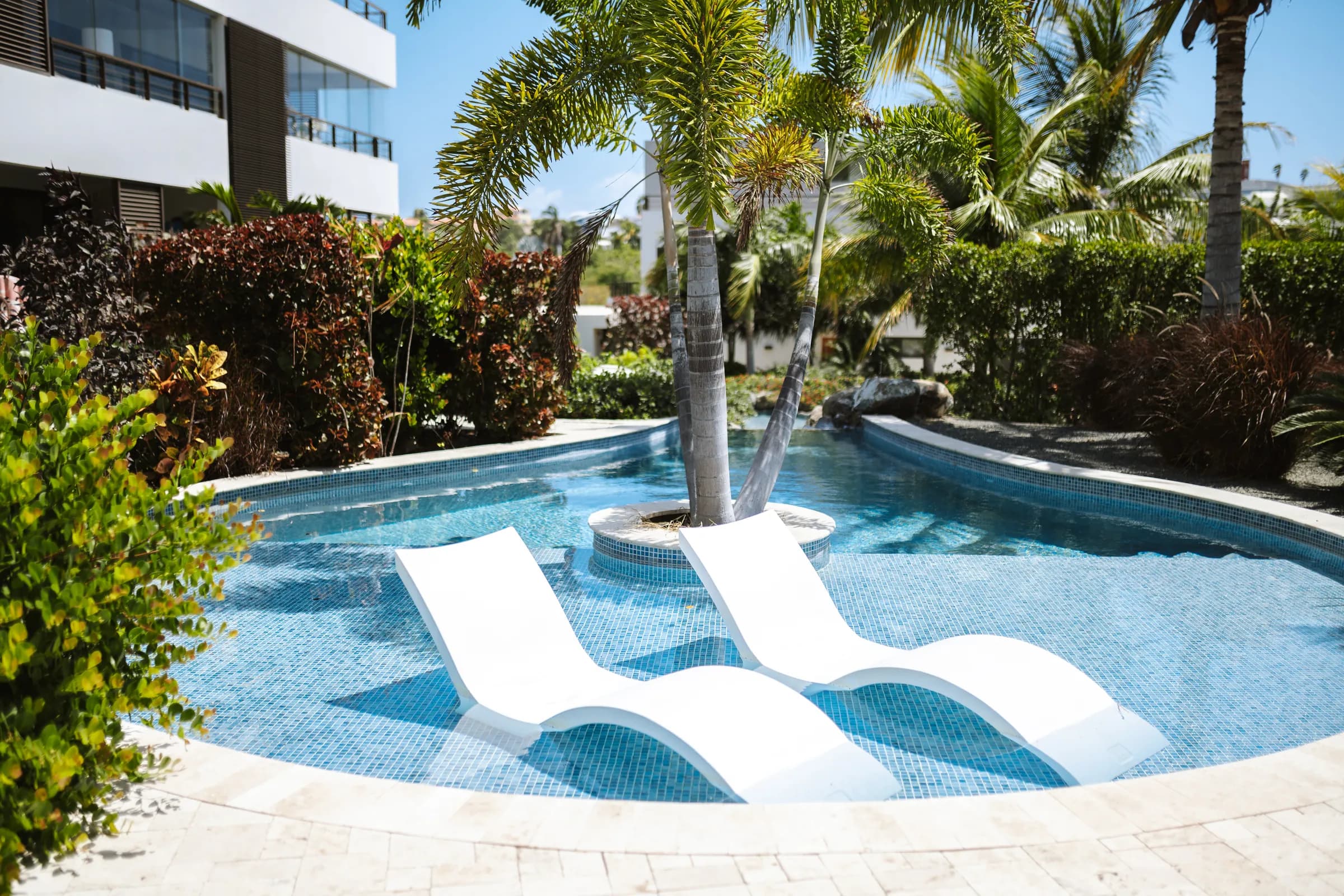 Zwembad met ligbedden in het water op Jan Sofat Luxury Resort