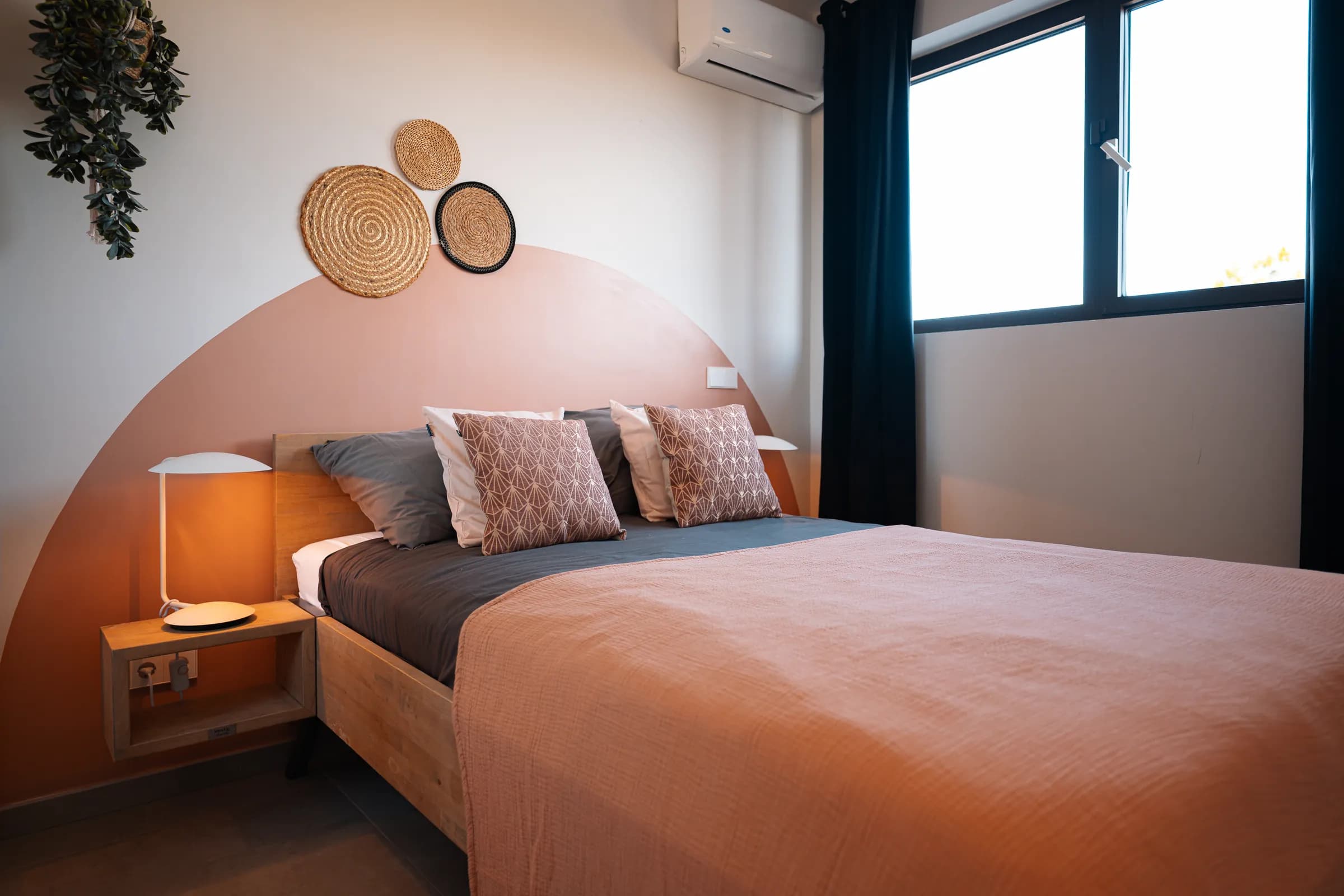 Slaapkamer met terracotta muur en tweepersoonsbed